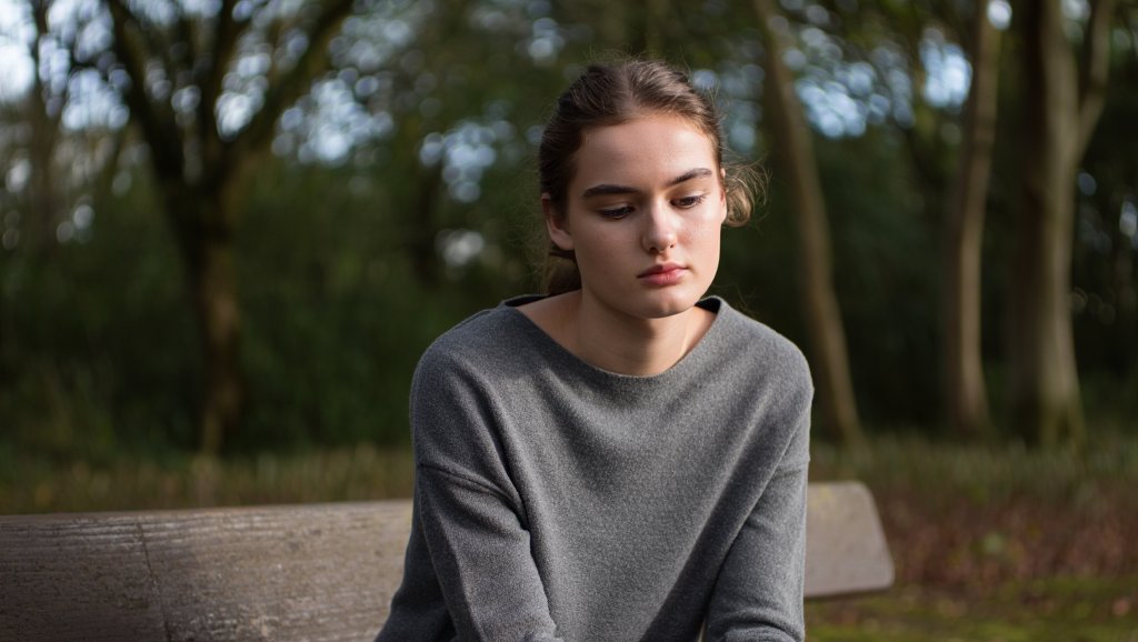 Девушка сидит в лесу